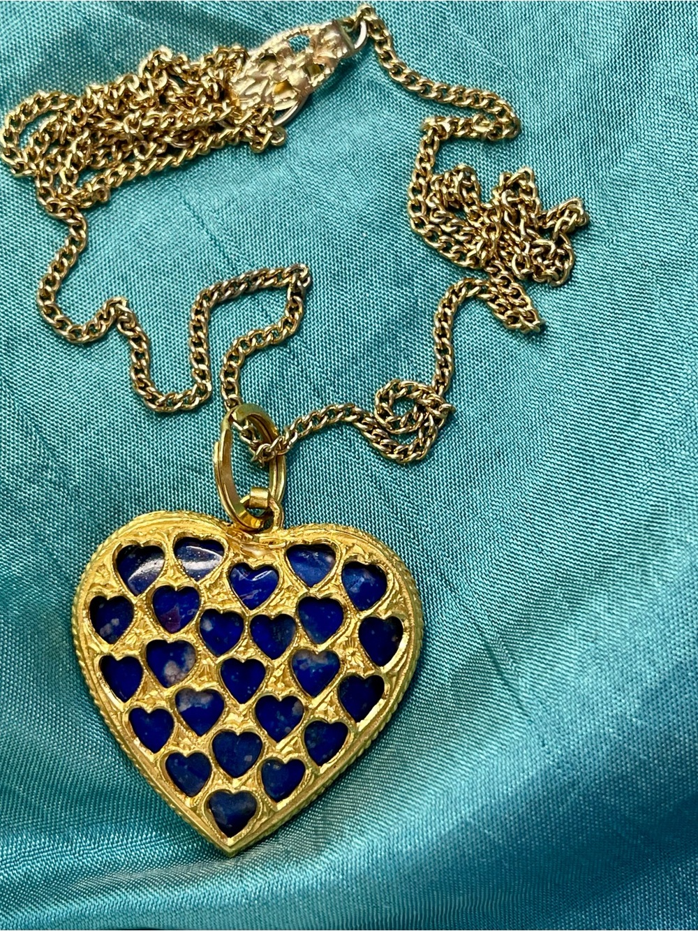 Pendant,heart shape with a lapis lazuli stone in a honeycomb case. Made of brass